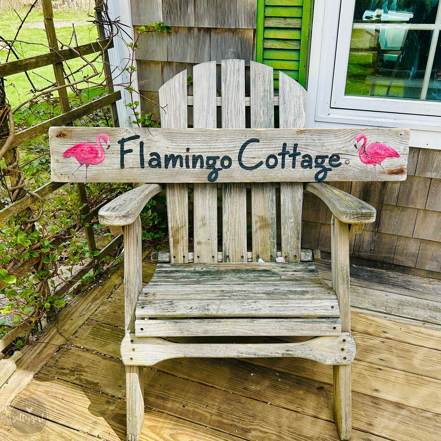 a wooden flamingo cottage chair sitting on a porch