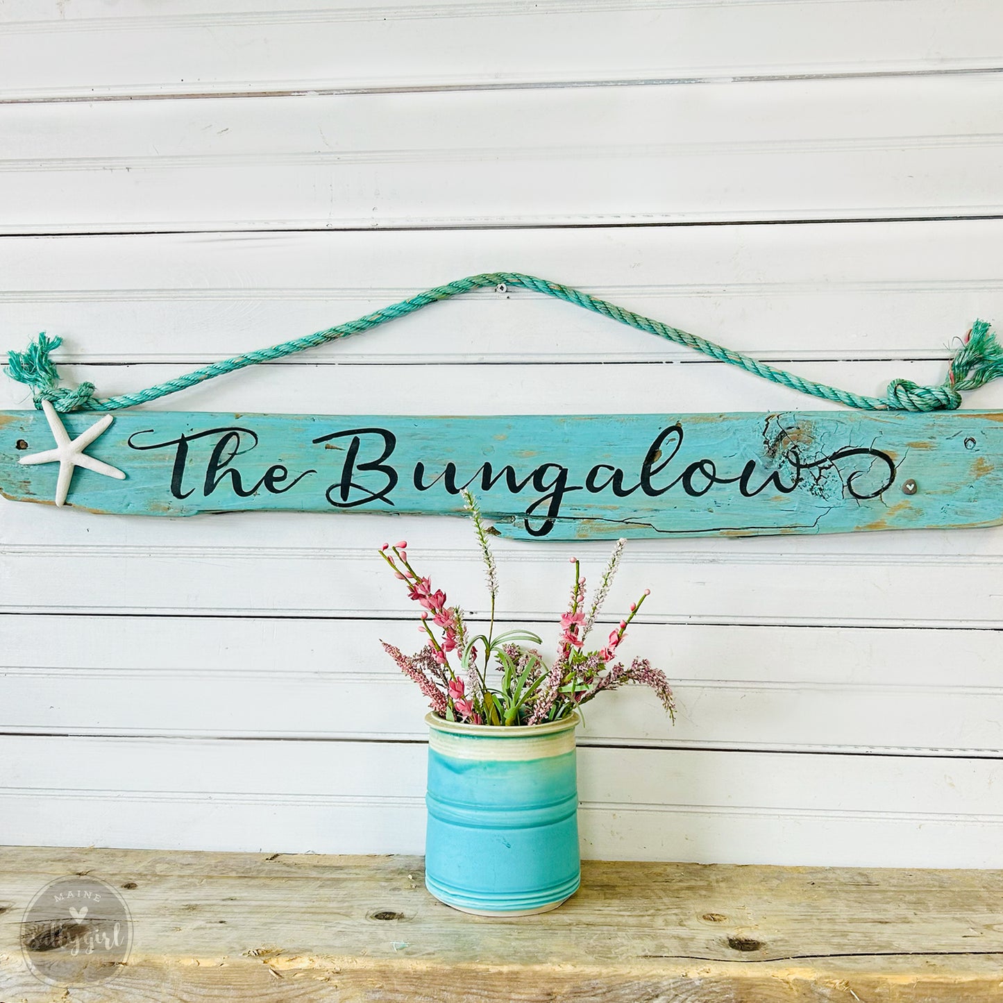 a sign that says the bungaloos hanging on a wall