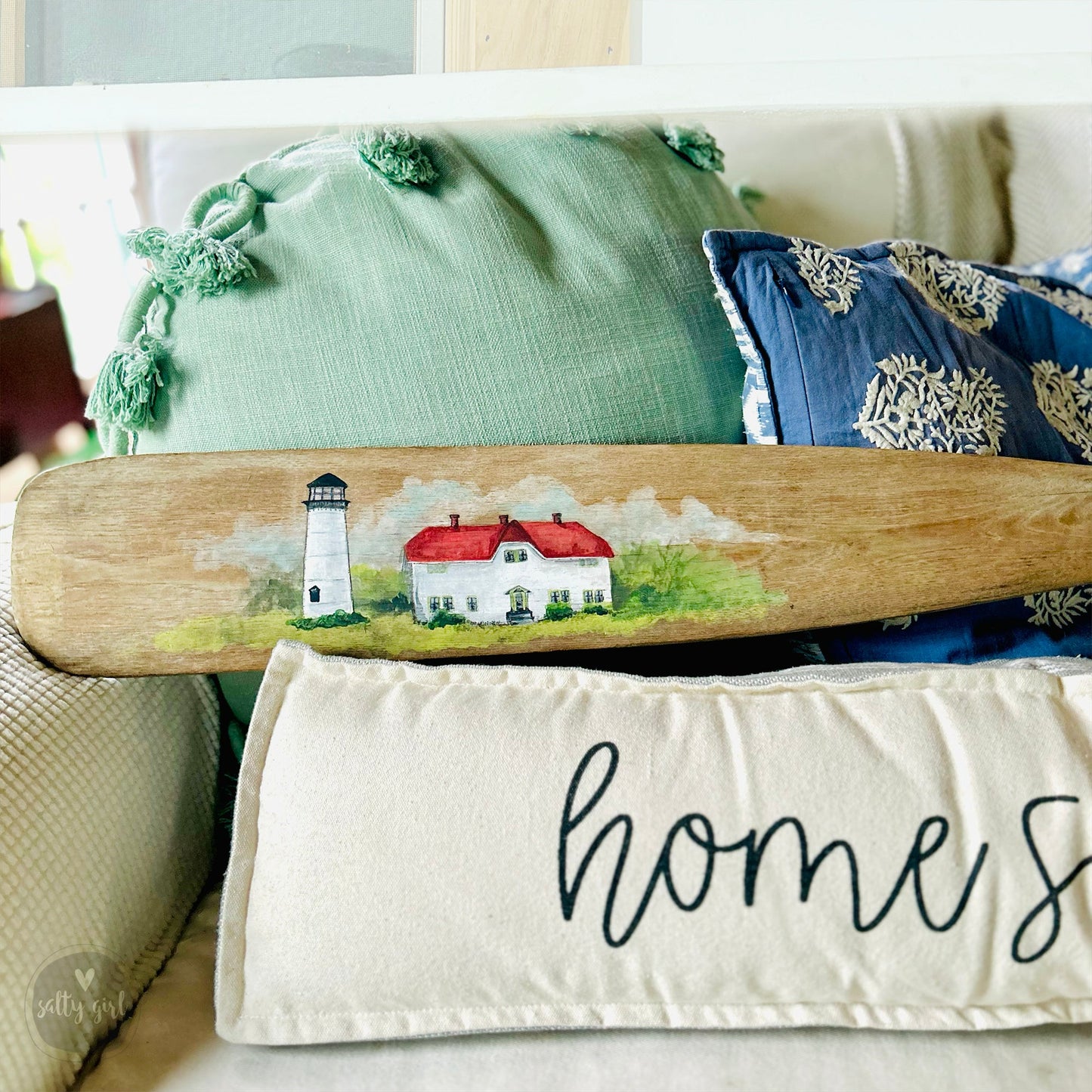 a surfboard sitting on top of a bed next to pillows