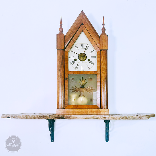 a small wooden clock on a shelf on a wall