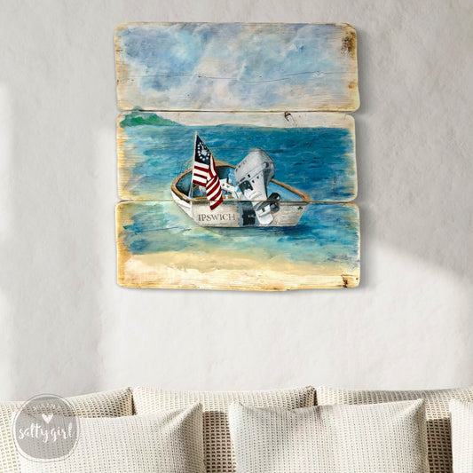 A wooden sign depicting a small boat with an American flag, floating on a body of water.