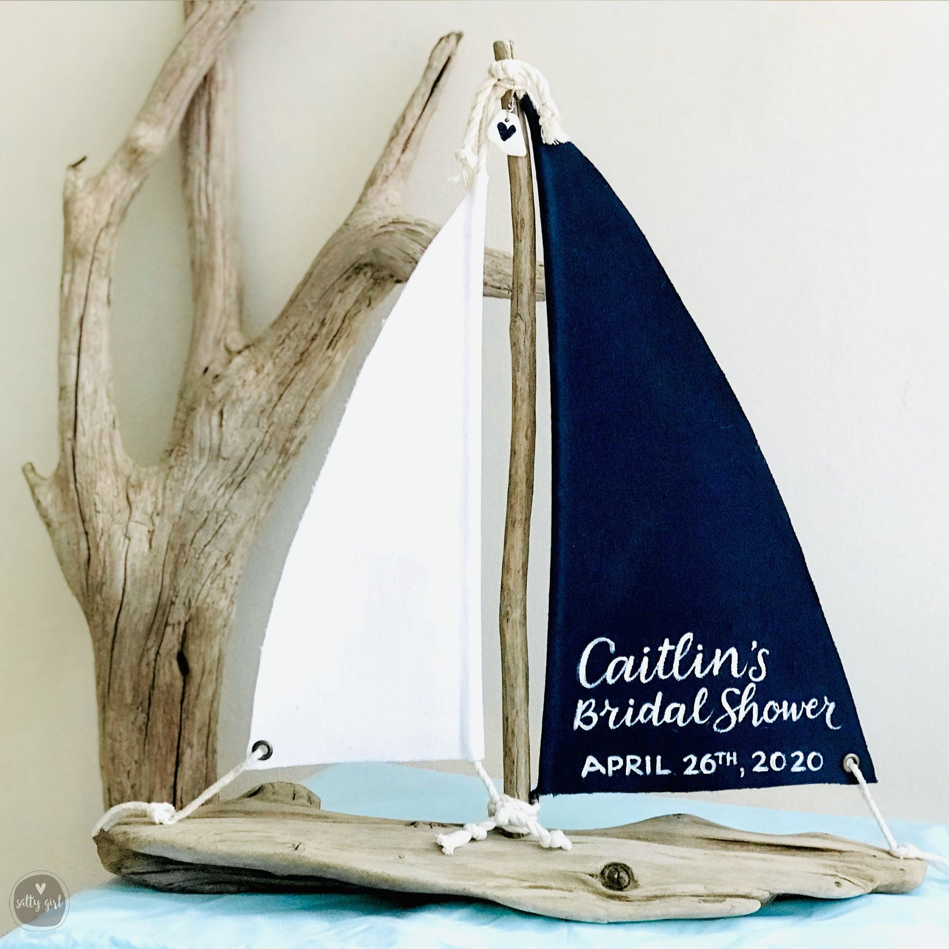 a sailboat is sitting on a table next to a tree