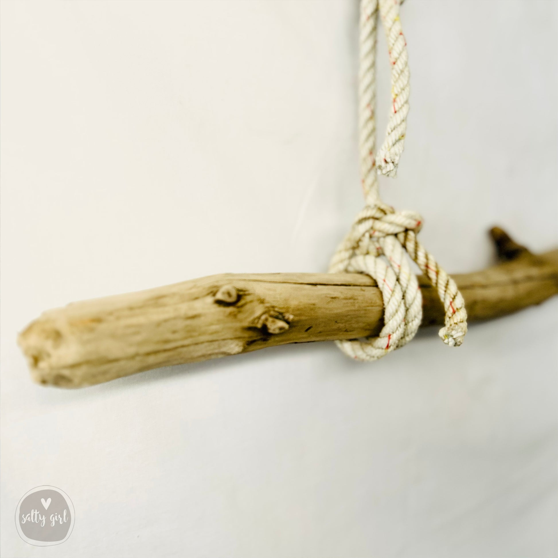 a piece of driftwood hanging from a rope