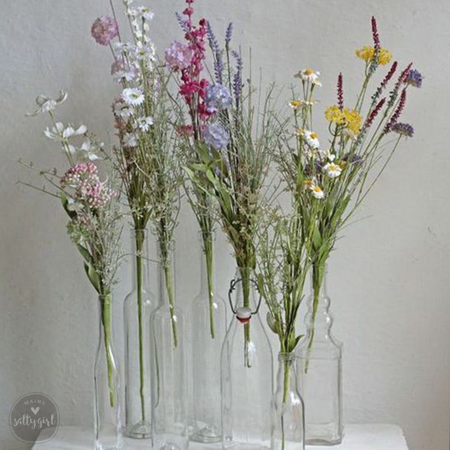 a group of vases filled with different types of flowers