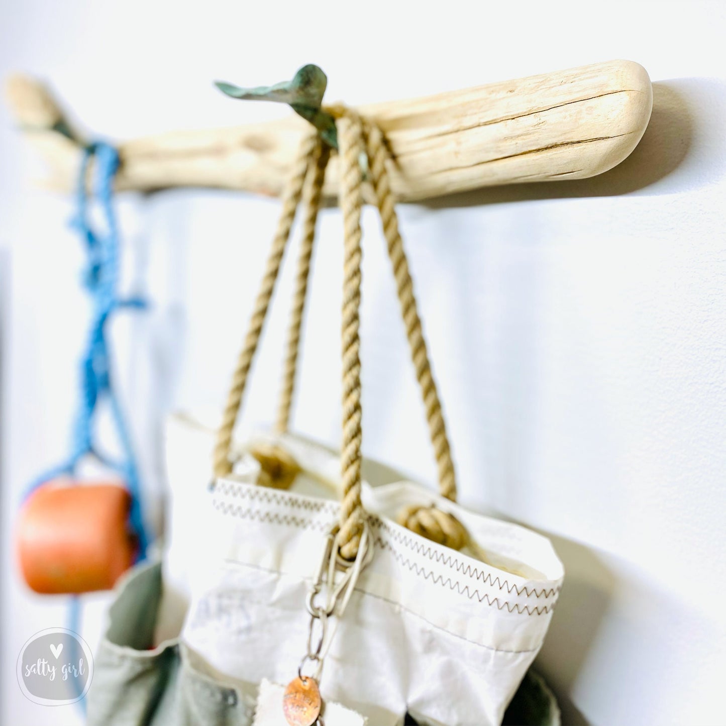 Driftwood Coat rack with hale tail hooks holding buoy and a Sea Bag