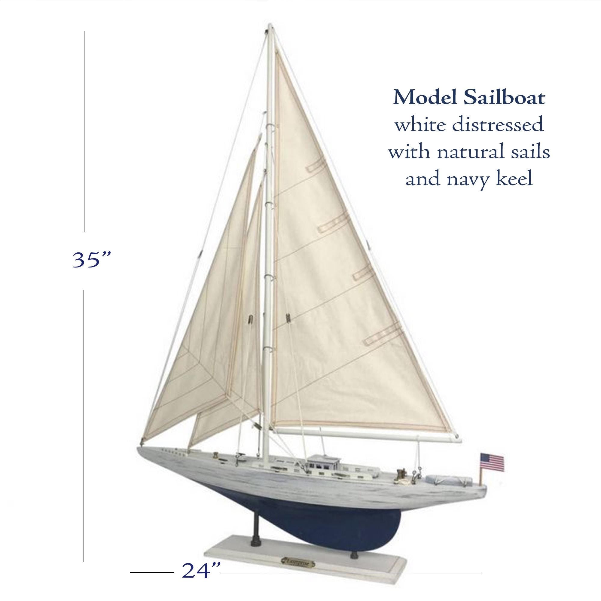 a model sailboat with a white hull and sails, and it is described as a 35-inch sailboat with natural sails and navy keel.