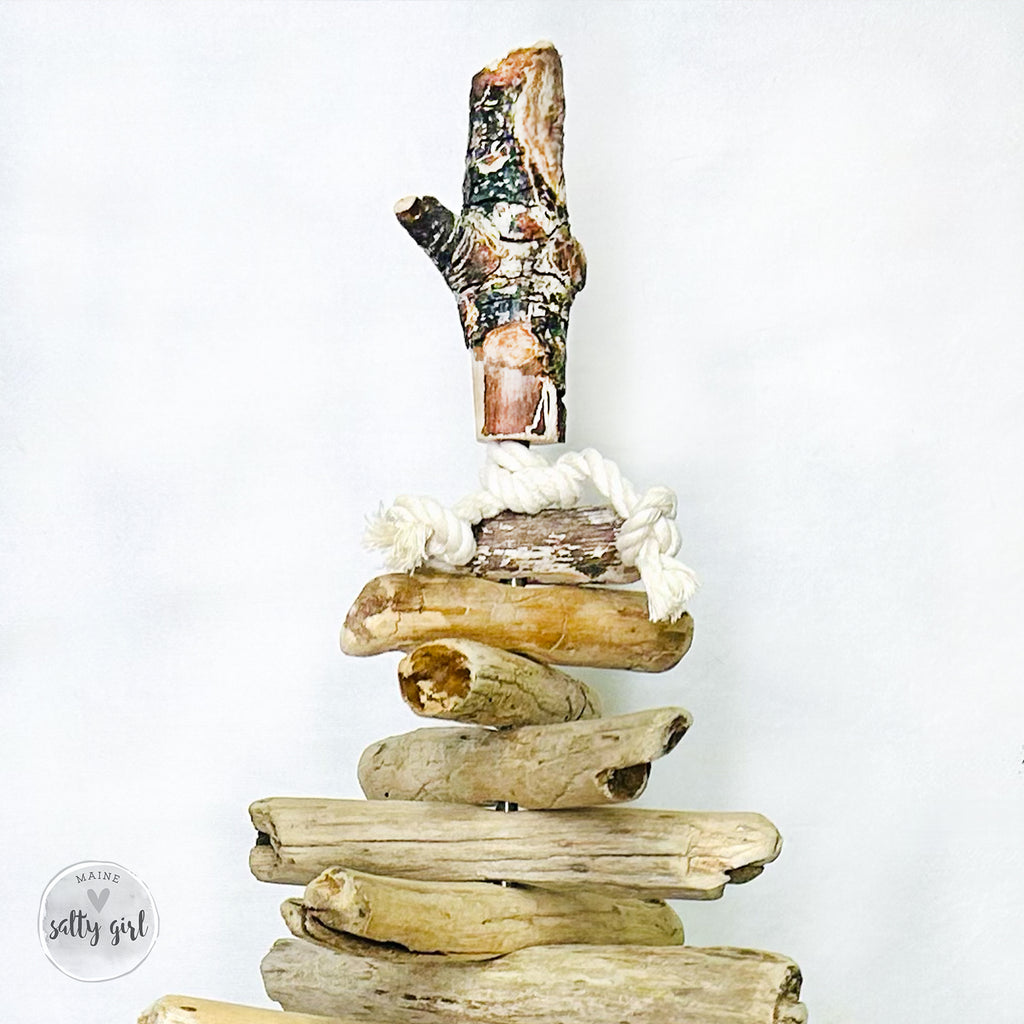 A stack of driftwood pieces arranged in a creative manner, resembling a tree or a sculpture.