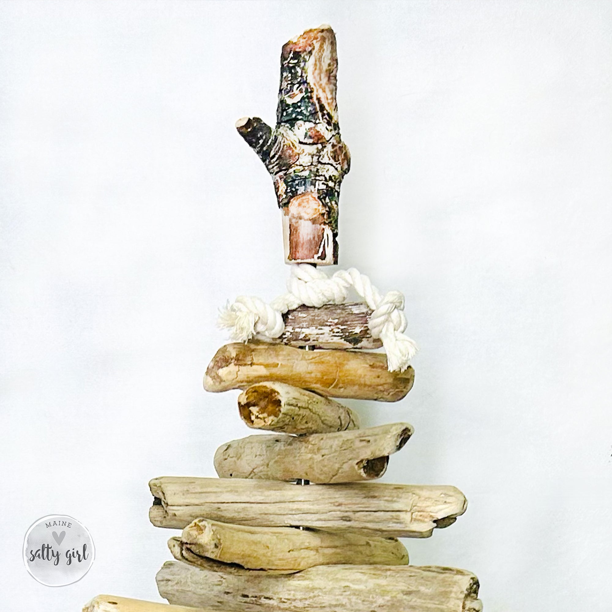 A stack of driftwood pieces arranged in a creative manner, resembling a tree or a sculpture.