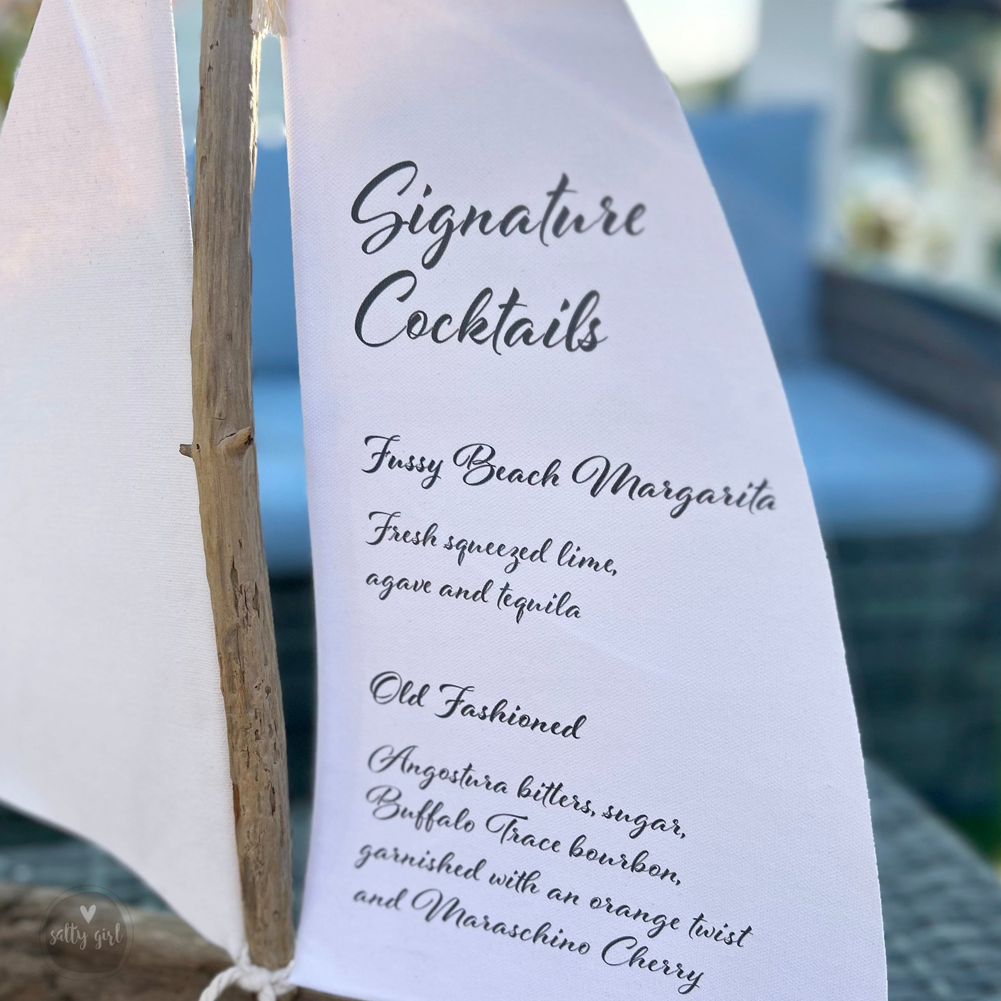 a menu card for signature cocktails, featuring a close-up view of the text and a blurred background.