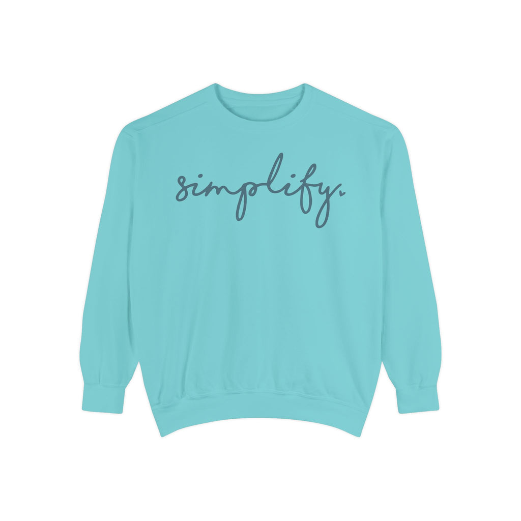 A turquoise-colored Maine Salty Girl sweatshirt with the word "simplify" printed on it in a cursive font.