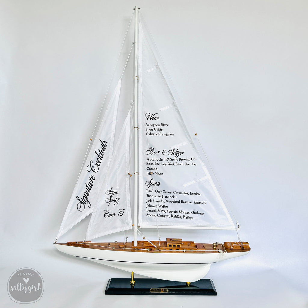 A model of a sailboat with a menu displayed on its sails.