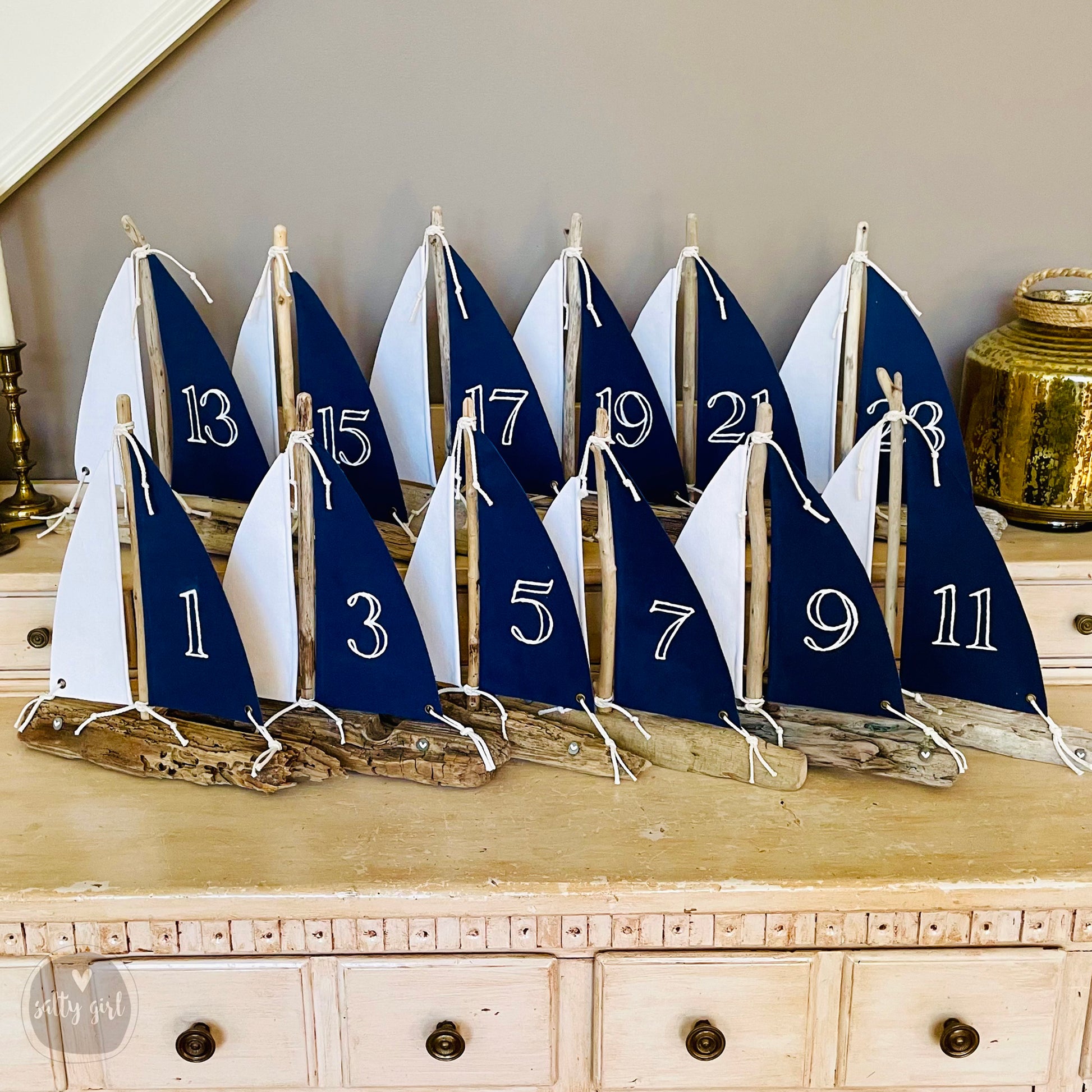 a row of sail boats sitting on top of a wooden table