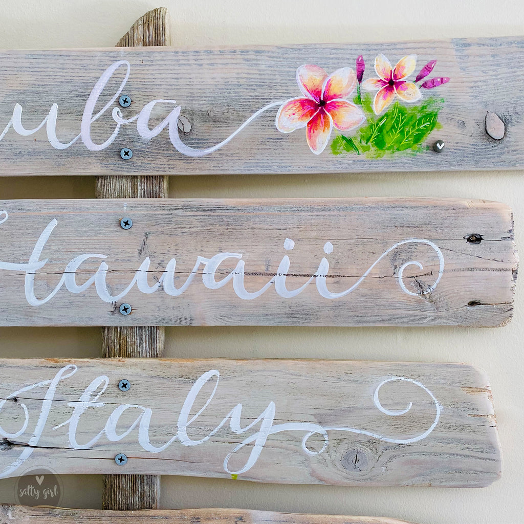 three wooden signs with flowers painted on them