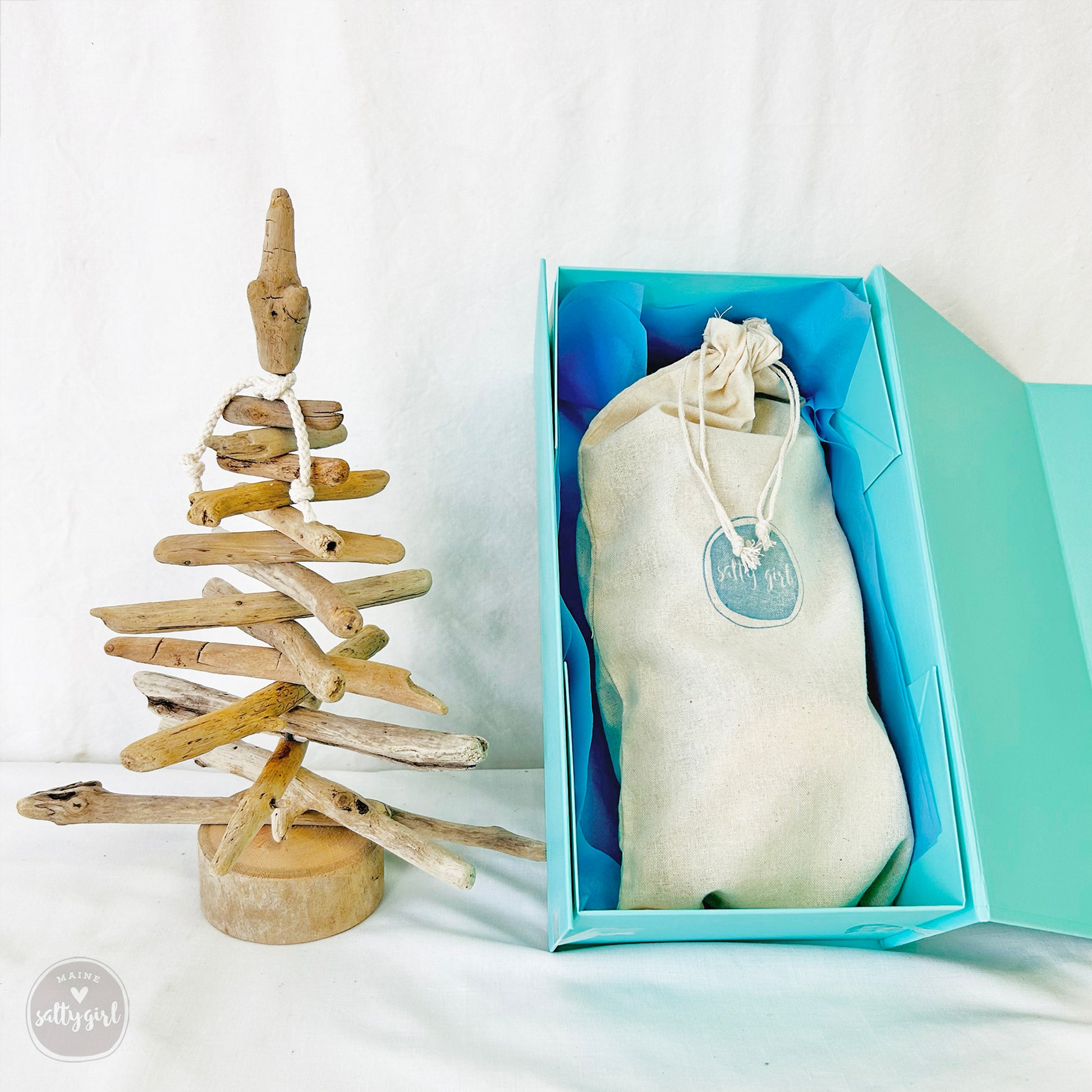 a small wooden christmas tree in a blue box