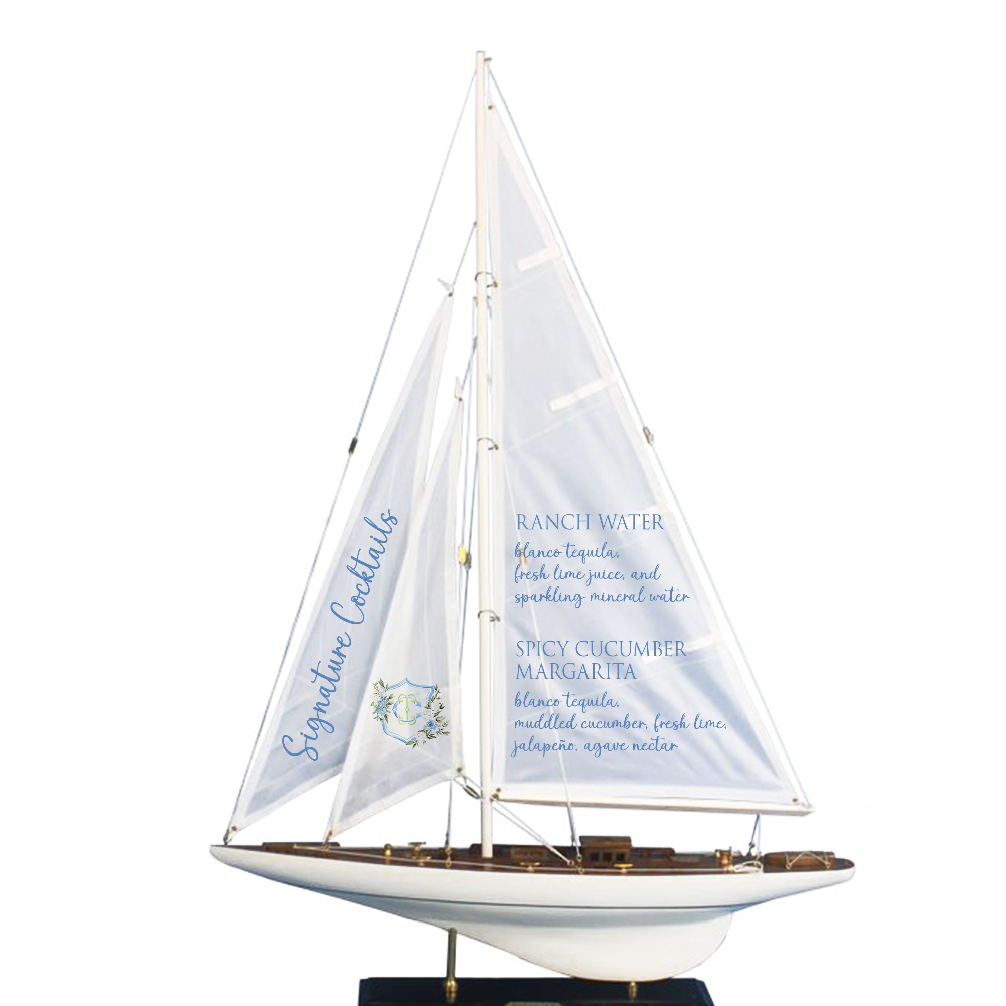 A model of a sailboat with a menu displayed on its sails, featuring various cocktail recipes.