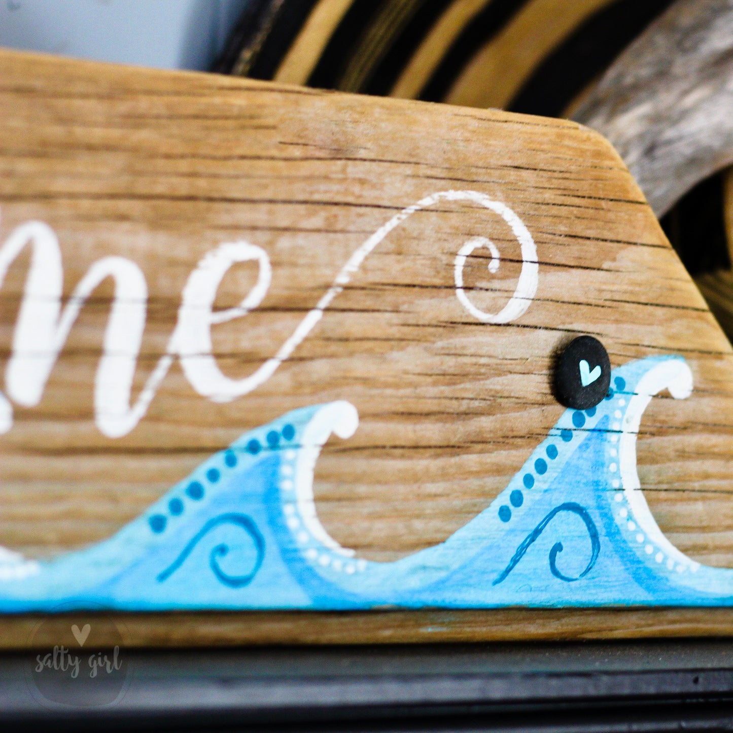 a wooden sign with a wave painted on it