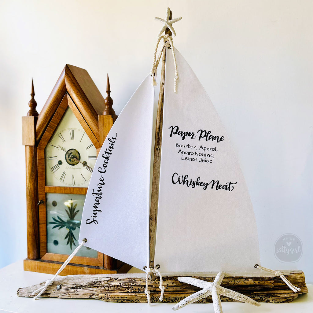 a small sail boat sitting next to a clock