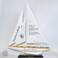 A model of a sailboat with a sign on the mast that reads "Signature Cocktails" and "Ocean's Grace".