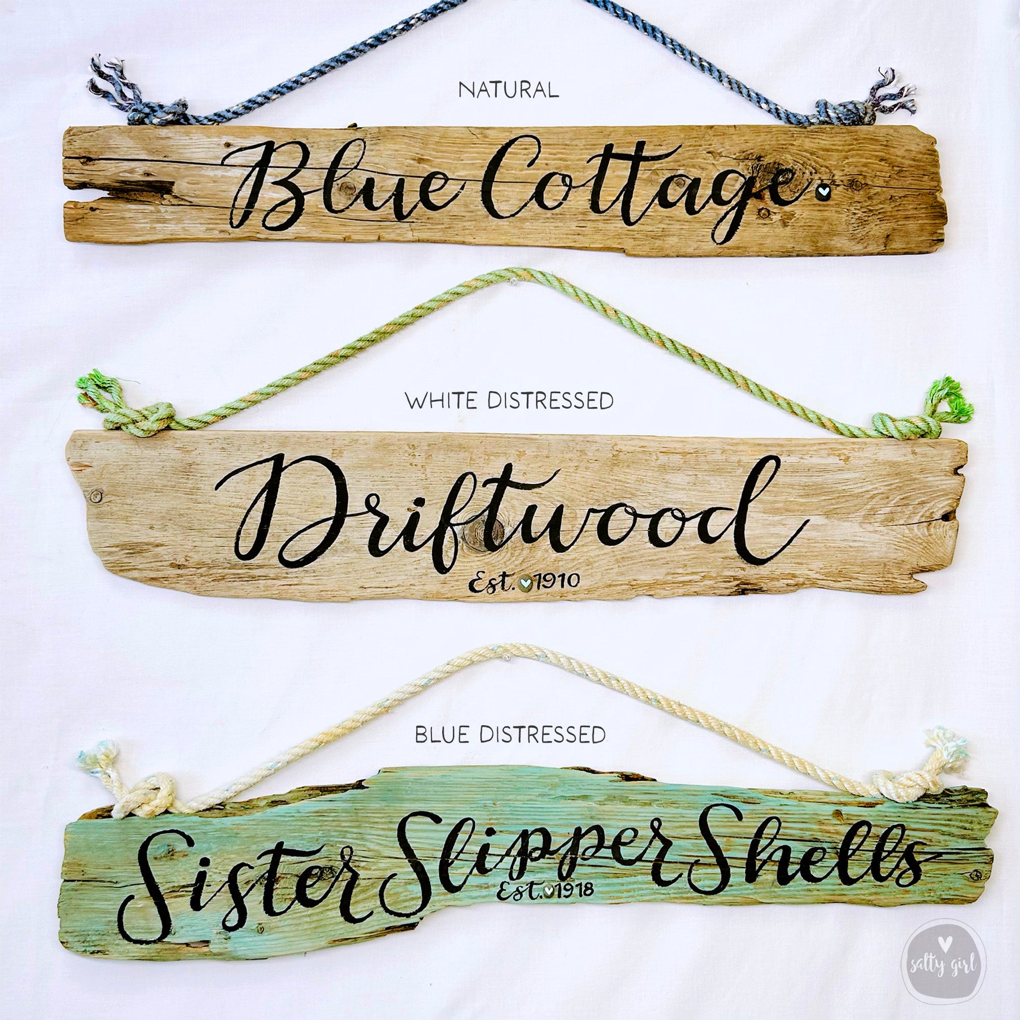 three different types of wooden signs, each with a unique color and style, hanging on a white background.
