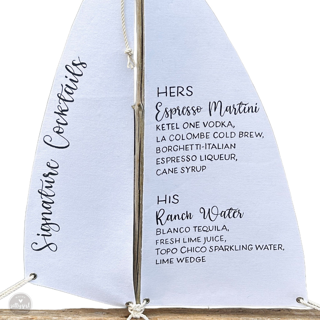 A white sailboat with black text listing cocktail names and descriptions.