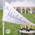 a banner with the name "The Welches" written on it, and a bucket filled with champagne bottles placed in front of it.