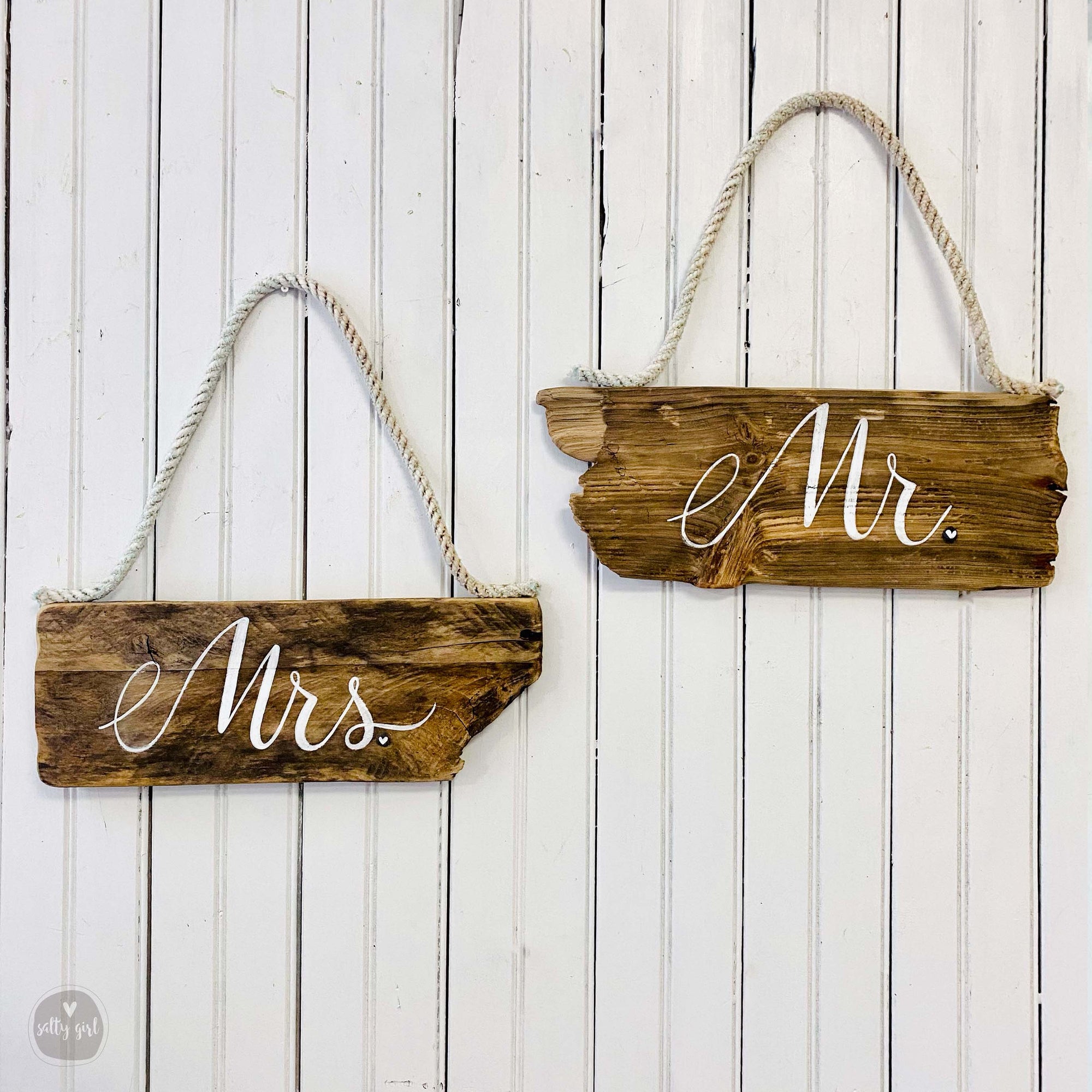 two wooden signs hanging on a white wall.