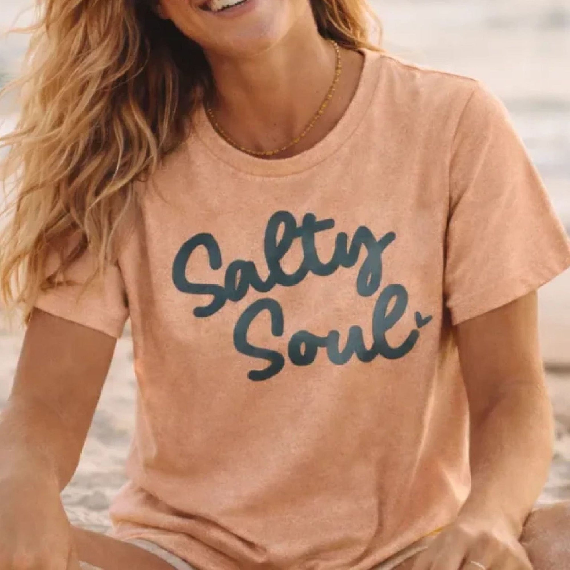 Person wearing a 'Salty Soul' t-shirt by the water