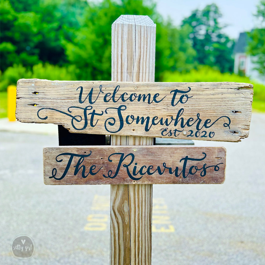 a wooden sign sitting on the side of a road