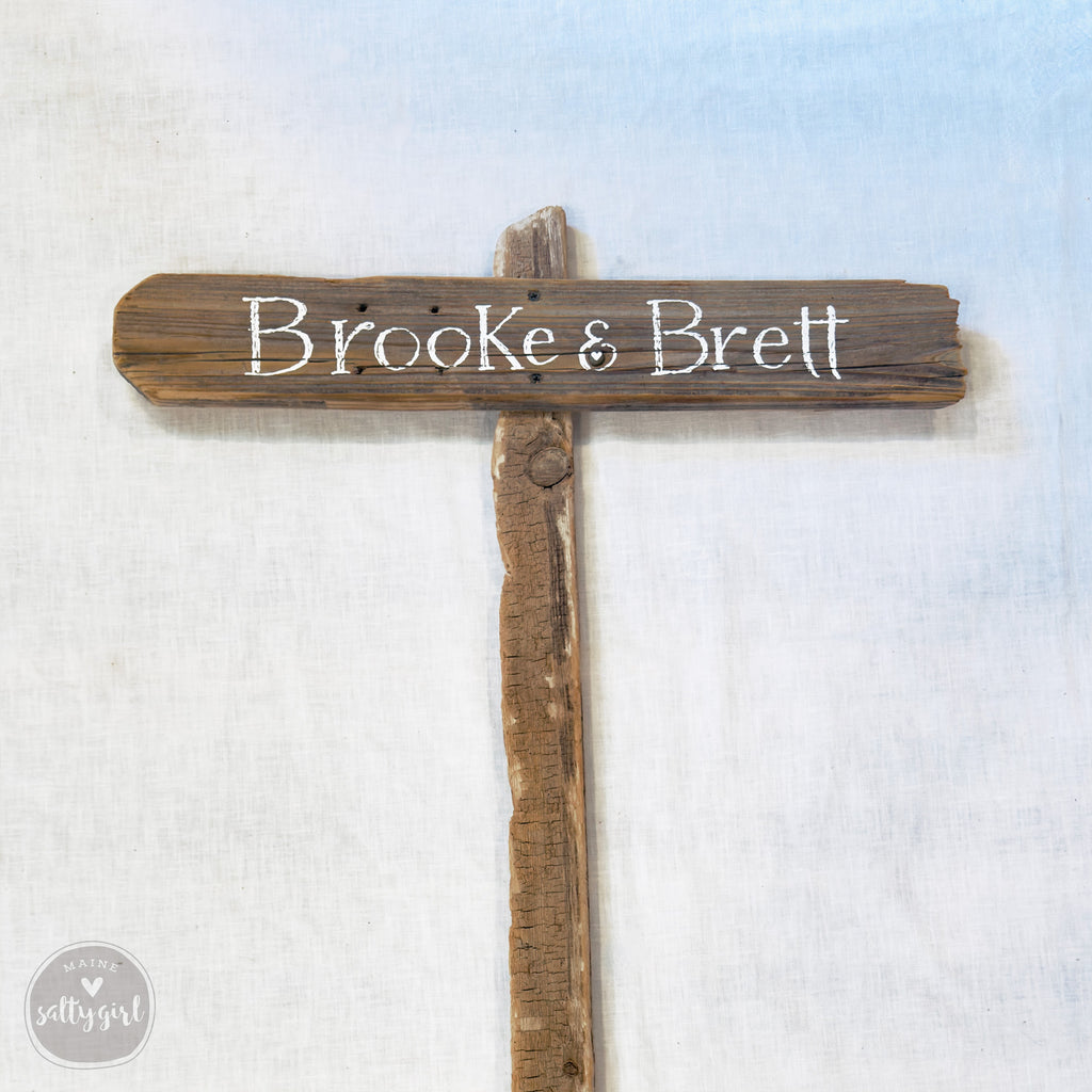 a wooden sign with the names "Brooke & Brett" written on it.