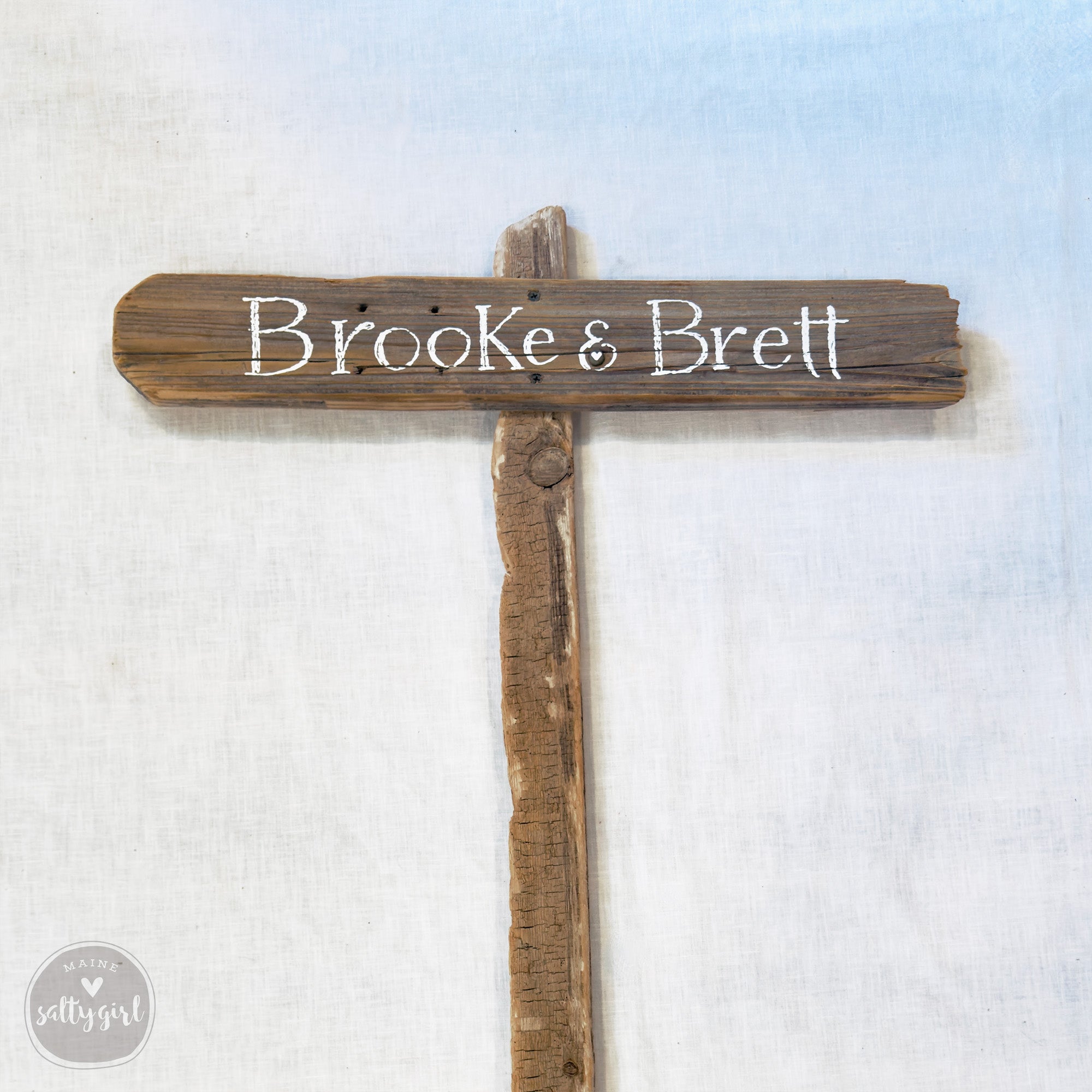 a wooden sign with the names "Brooke & Brett" written on it.