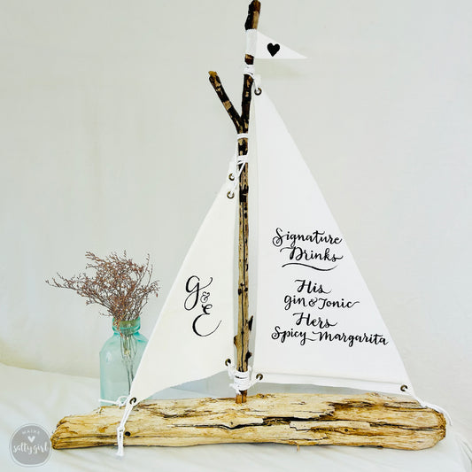 a wooden sailboat is on display with a vase of flowers