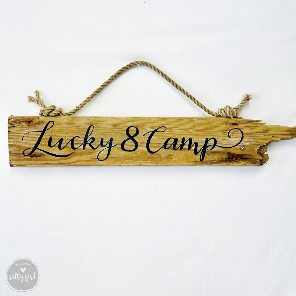A wooden sign with the text "Lucky 8 Camp" written on it.