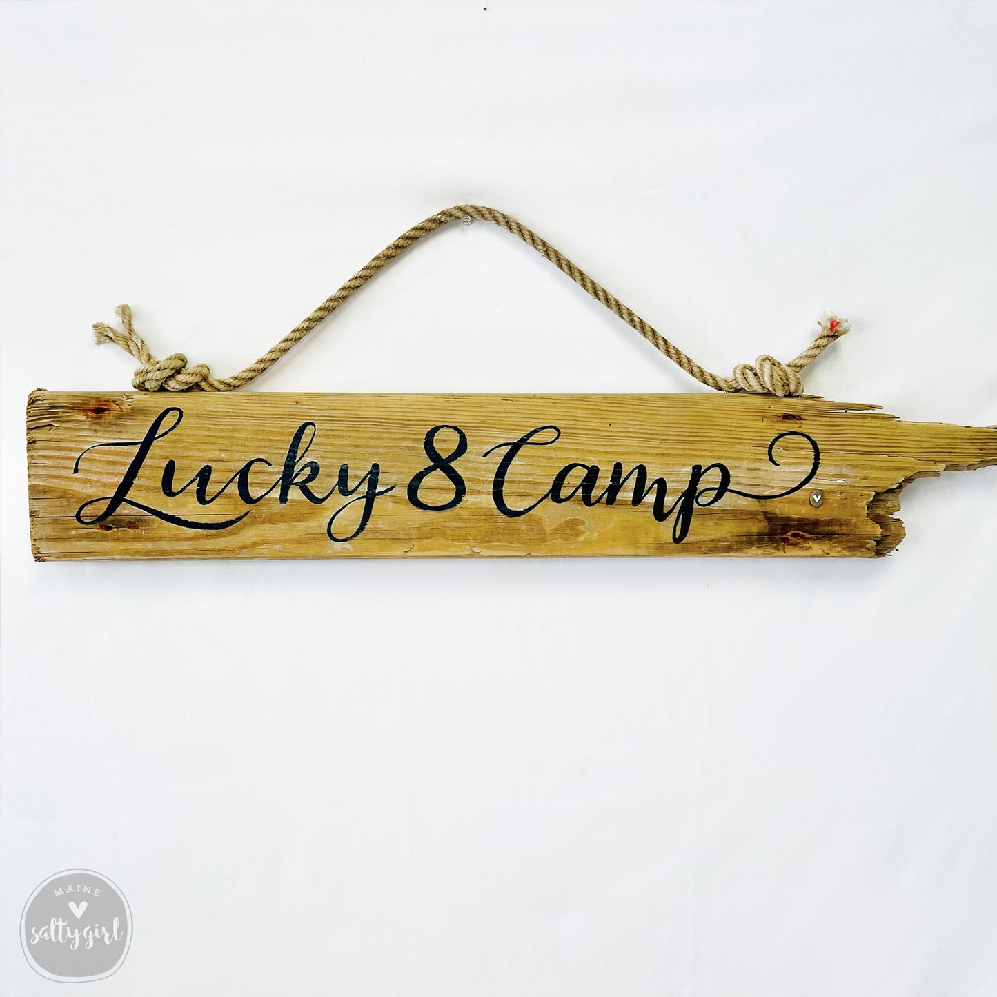 A wooden sign with the text "Lucky 8 Camp" written on it.