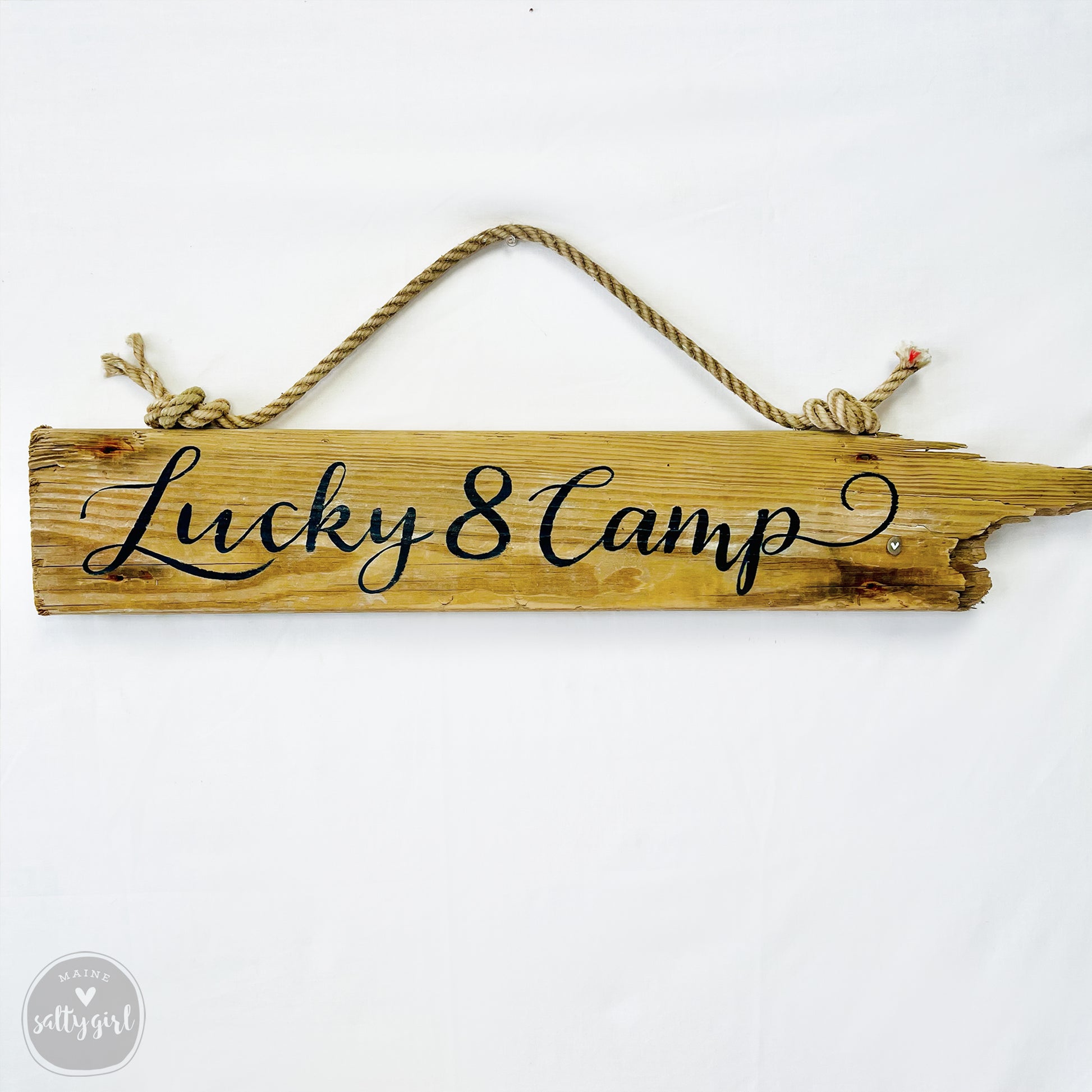 A wooden sign with the text "Lucky 8 Camp" written on it.