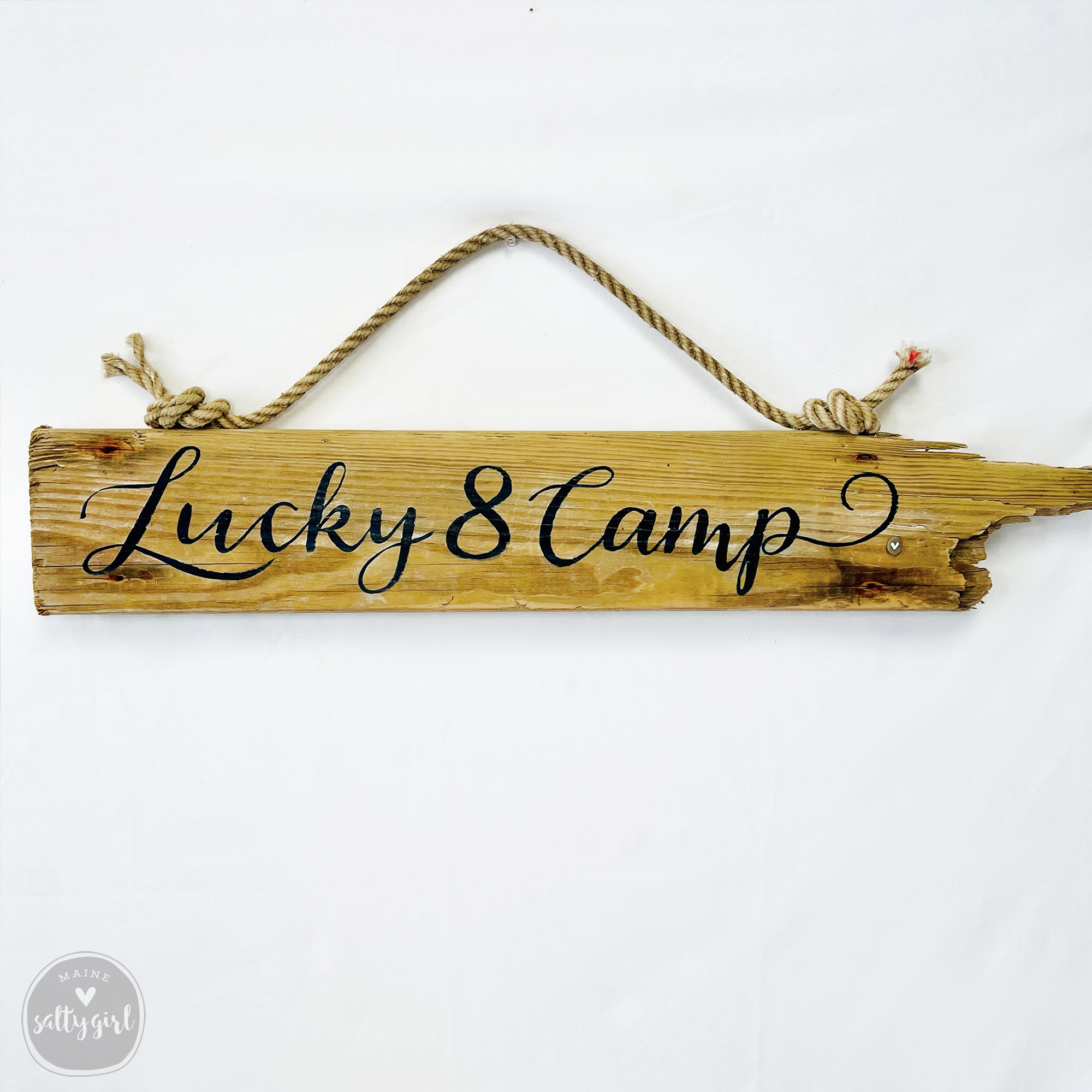 A wooden sign with the text "Lucky 8 Camp" written on it.