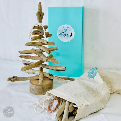 a small wooden christmas tree next to a blue box