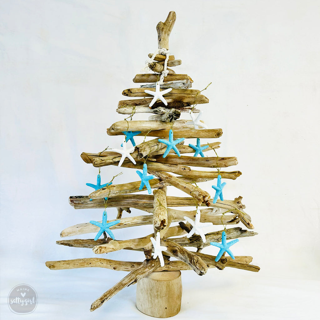 A unique, handcrafted Christmas tree made from driftwood, adorned with blue and white starfish ornaments.
