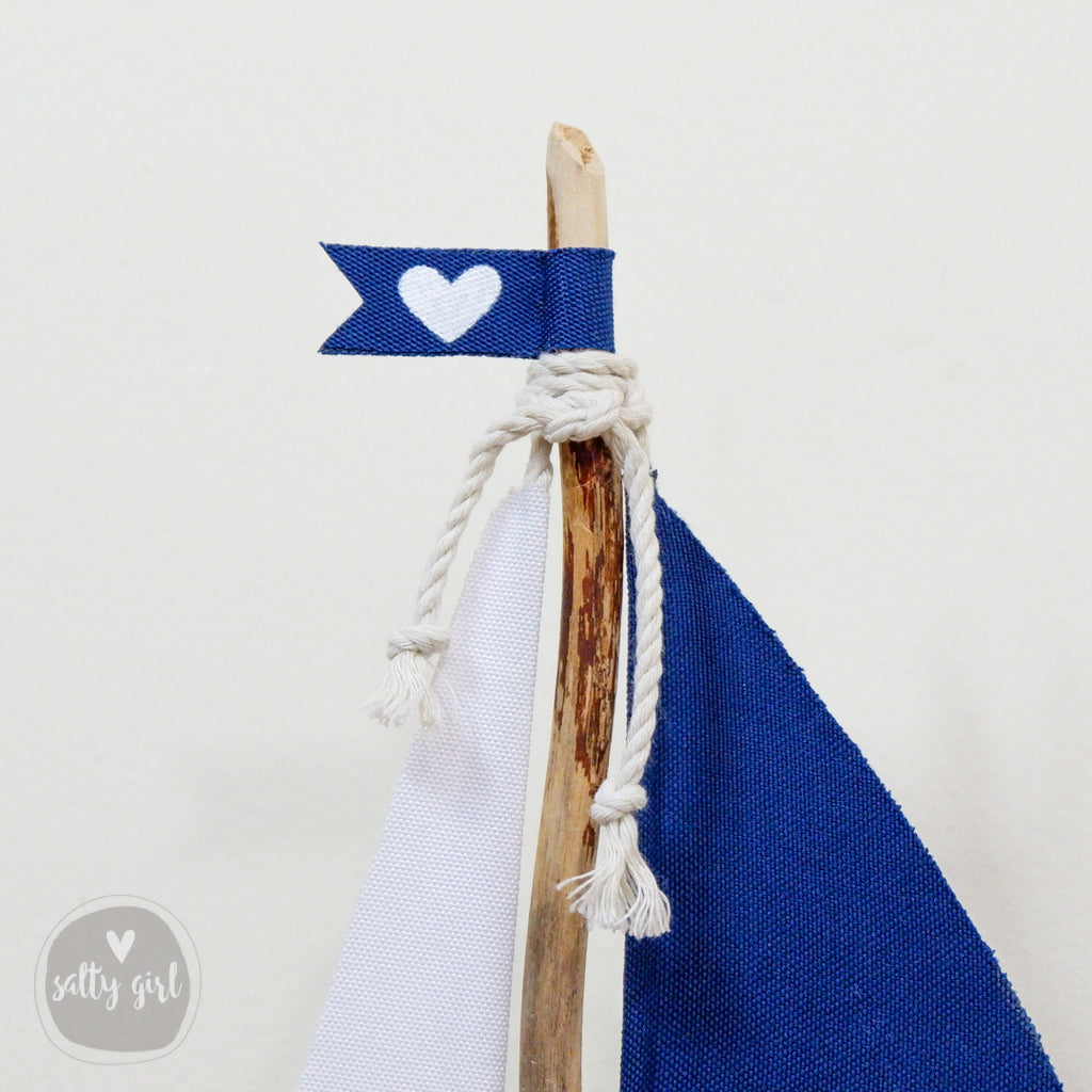 a blue and white sailboat with a heart on it
