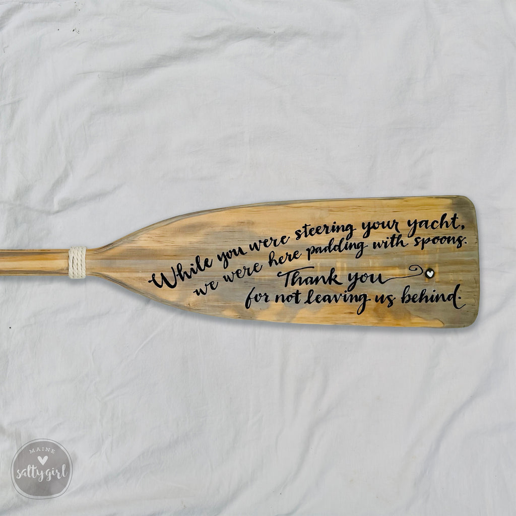 a wooden paddle with a message written on it.