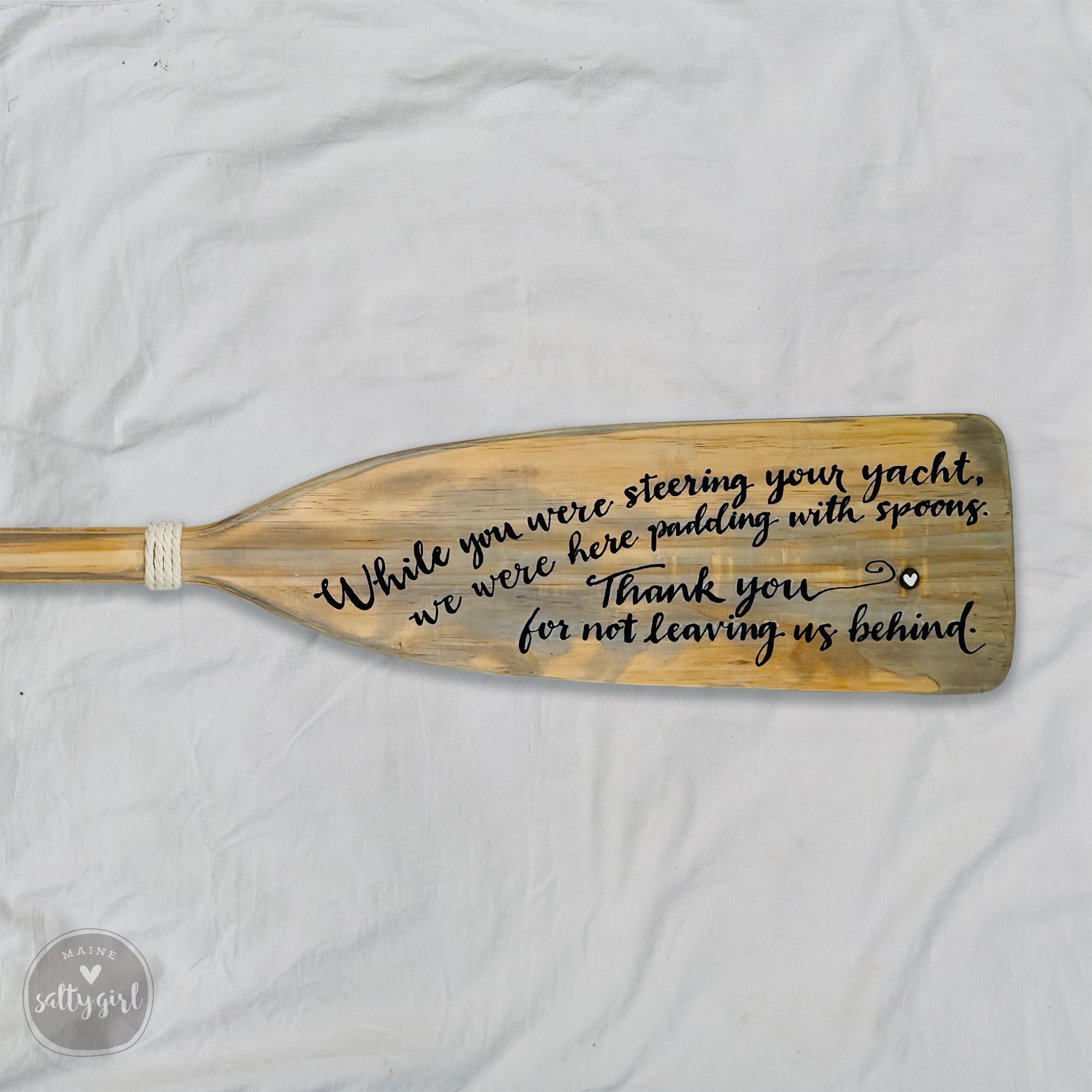 a wooden paddle with a message written on it.