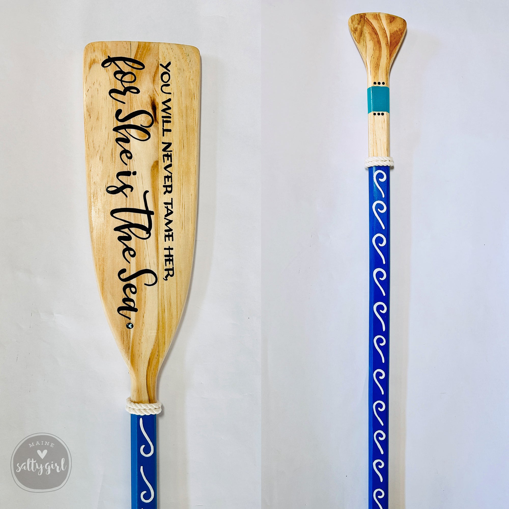 two wooden oars with blue and white designs on them, standing upright against a white background.