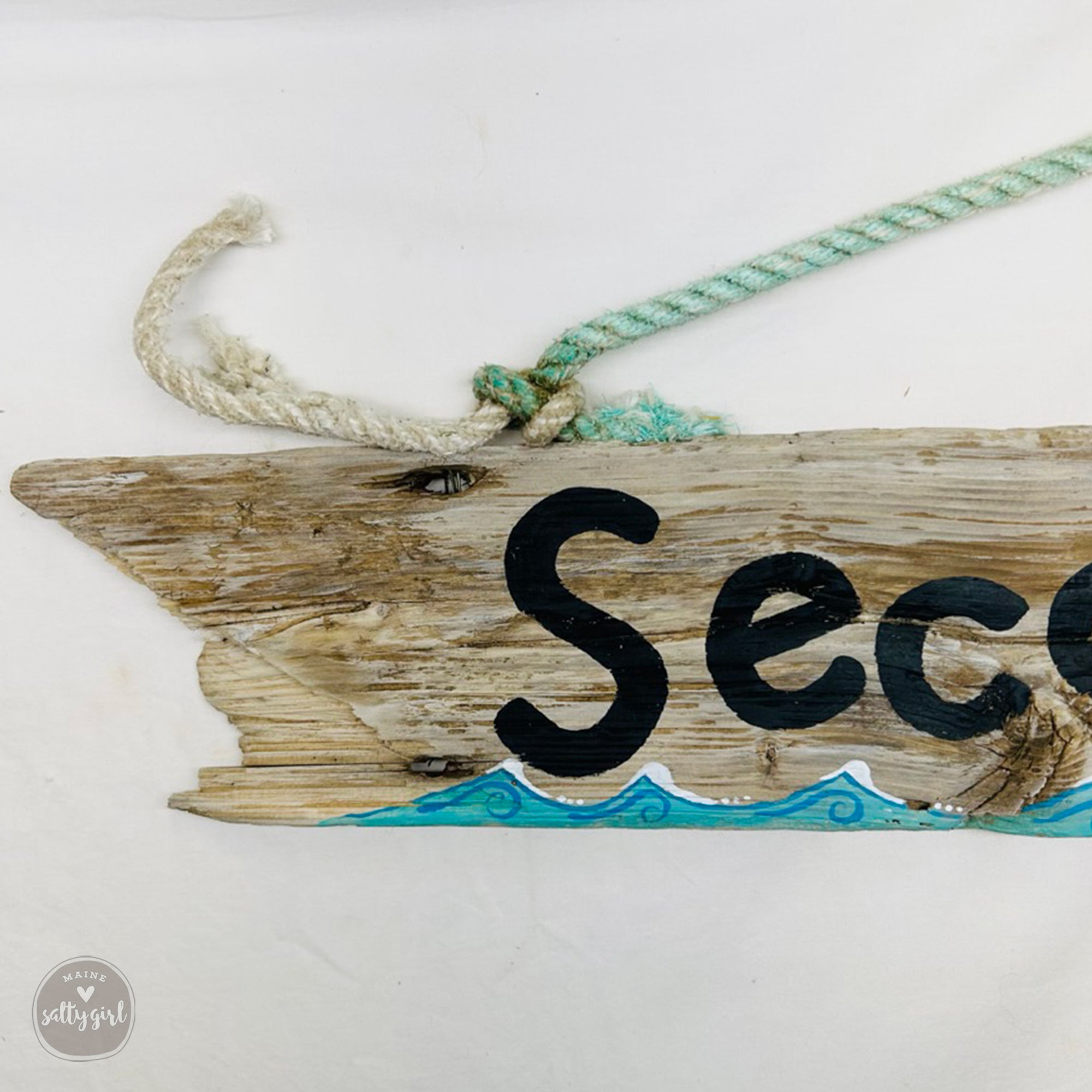 A wooden sign with the word "Sec" painted on it, along with a rope and a blue wave design.