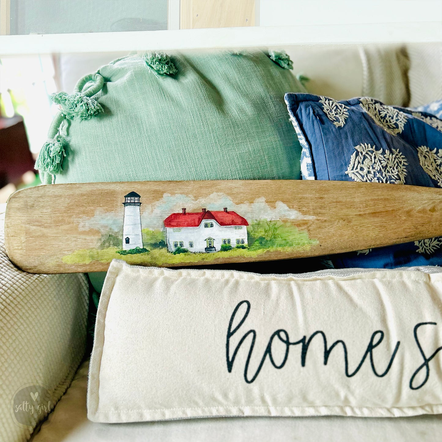 a surfboard sitting on top of a bed next to pillows