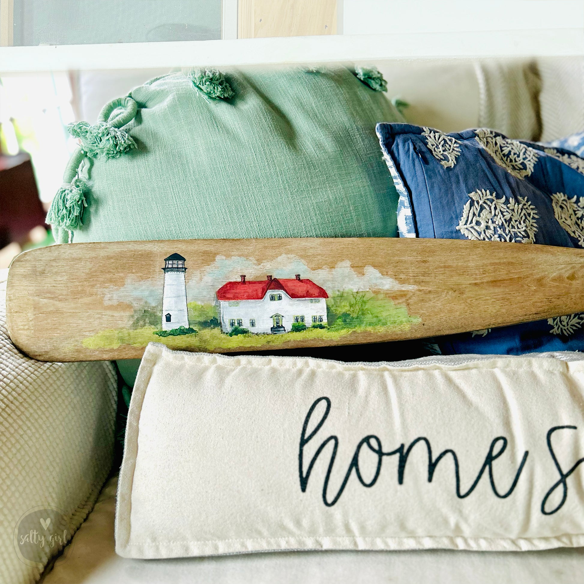 a surfboard sitting on top of a bed next to pillows