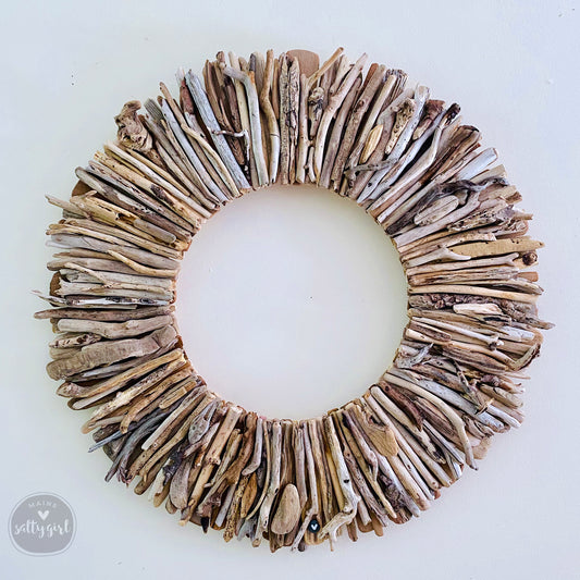 A wreath made of various natural materials, including sticks, branches, and leaves, arranged in a circular pattern.
