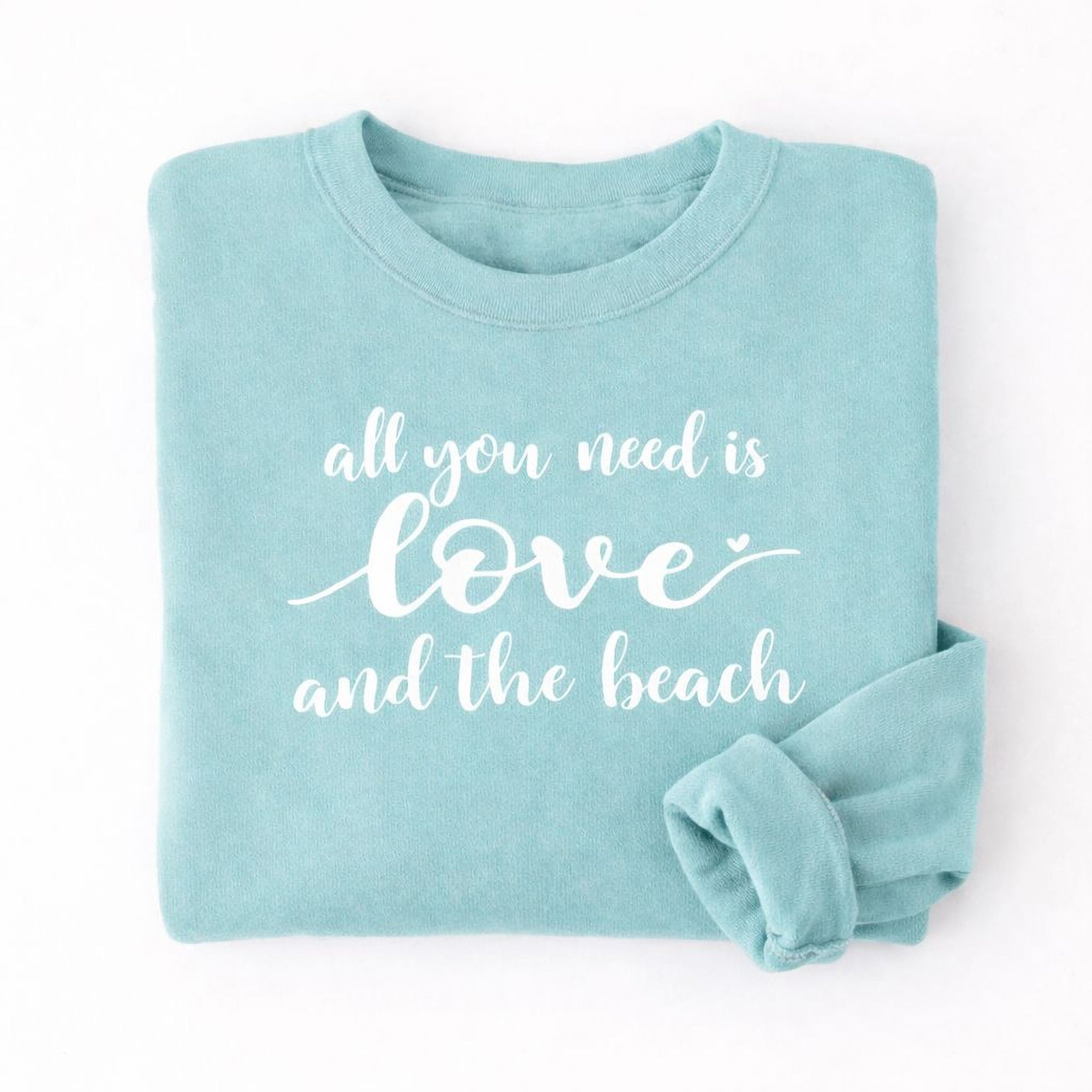 A light blue Maine Salty Girl sweatshirt with the text "all you need is love and the beach" printed on it.
