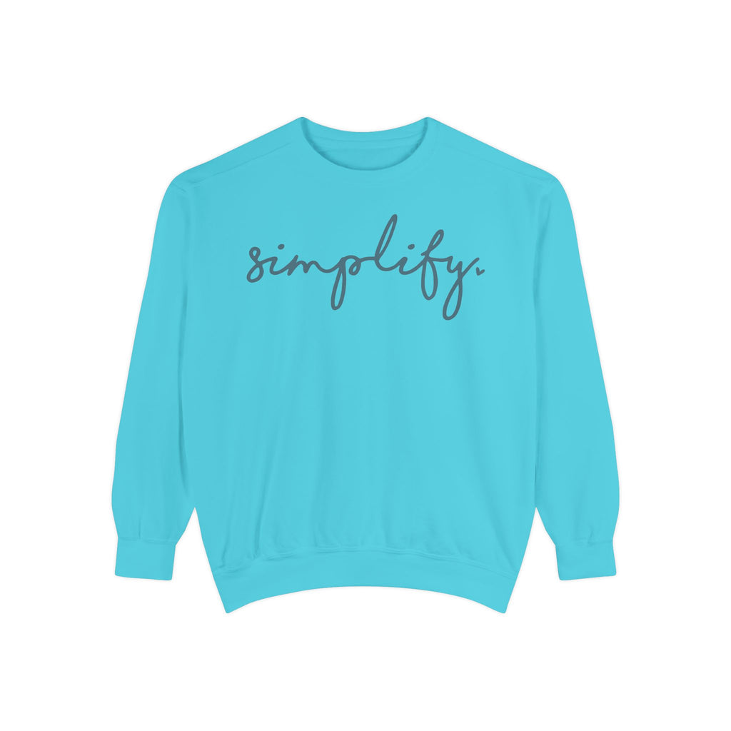 A turquoise-colored Maine Salty Girl sweatshirt with the word "simplify" printed on it in a cursive font.