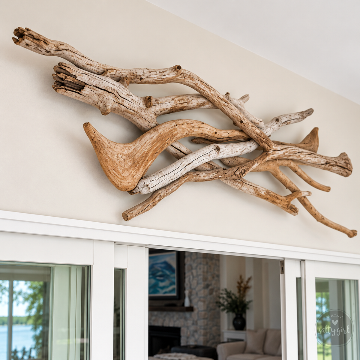 a unique piece of driftwood art displayed on a wall, with a view of a living room through a sliding glass door in the background.