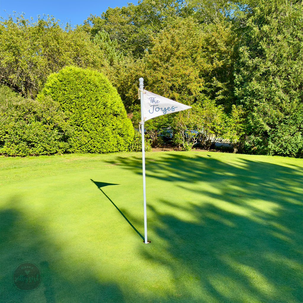 Golf flag on a green golf course with trees in the background