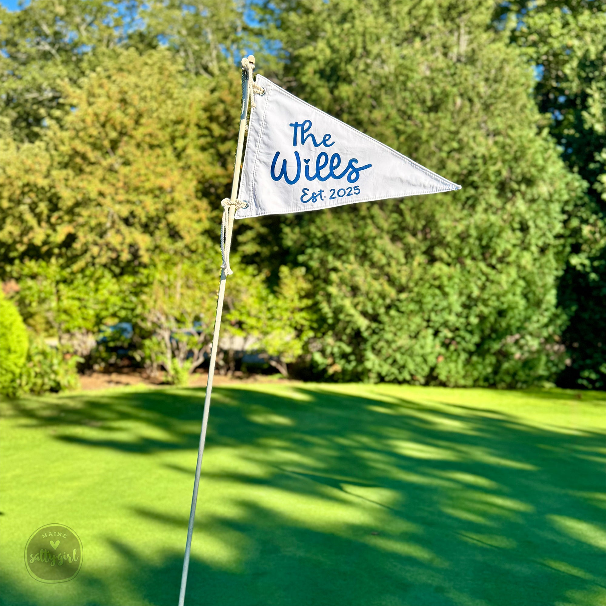 Golf flag with 'The Wills Est 2023' text on a green golf course